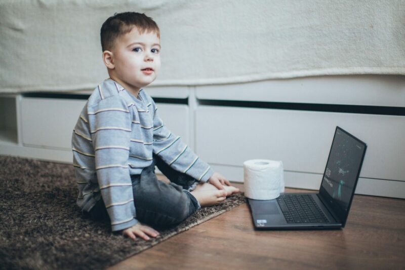 Kind mit Klopapier vor dem laptop
